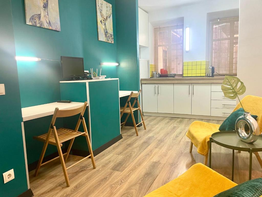 a living room with a green wall and a kitchen at Апартаменти в центрі старого Львова in Lviv