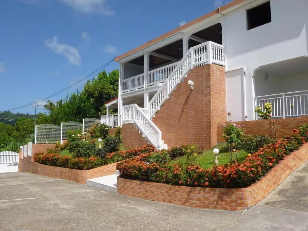 a building with a staircase and flowers in front of it at Appartement familial à Saint-Esprit, 95m² avec terrasse in Quartier Palmène