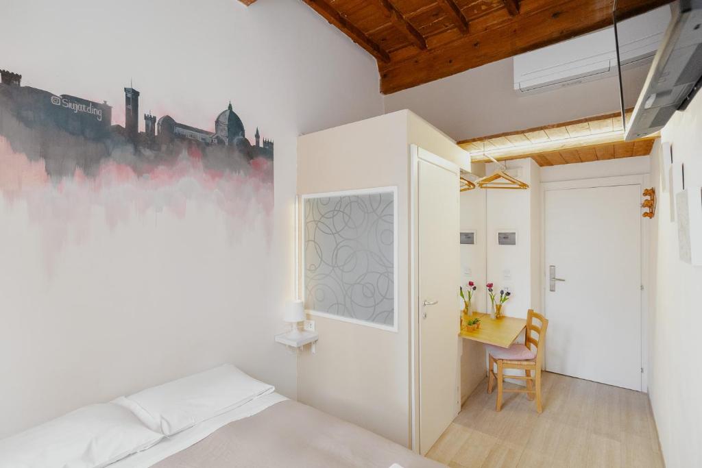 a bedroom with a bed and a desk at 21 Duomo - Camera con bagno privato in Florence