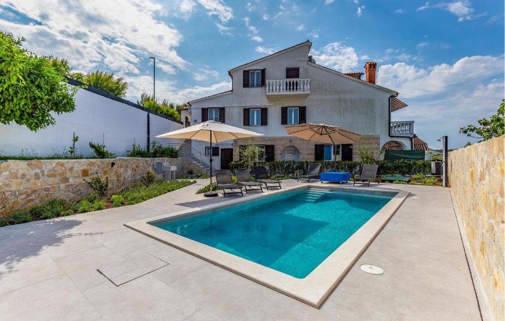a villa with a swimming pool in front of a house at Nice Apartment In Medulin in Medulin