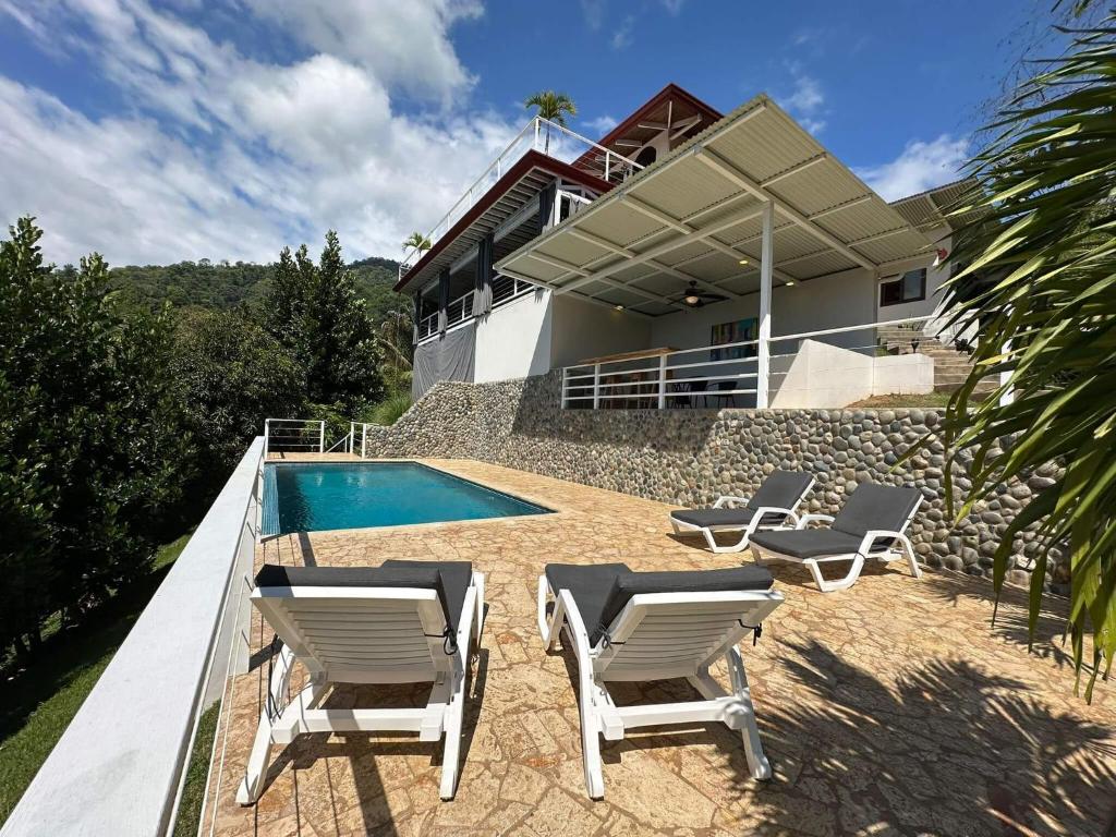 Playa HermosaUvita-ocean Views-large Pool-great Patio的一座带游泳池和两把草坪椅的房屋