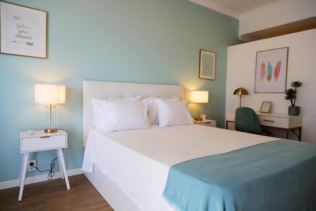 een slaapkamer met een groot wit bed en een bureau bij Seaside Lovers in Monte Gordo