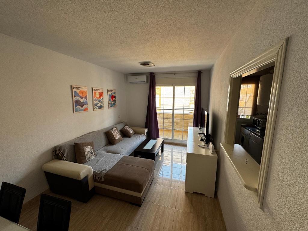 a living room with a couch and a television at Brisa y Mar Aguadulce II in Aguadulce
