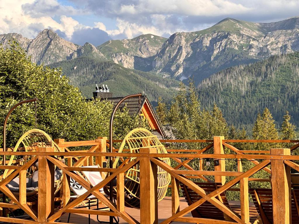 a wooden playground with mountains in the background at Hacienda Kościelisko - Kierpcówka 5 - Apartamenty z widokiem na Tatry & SPA in Kościelisko