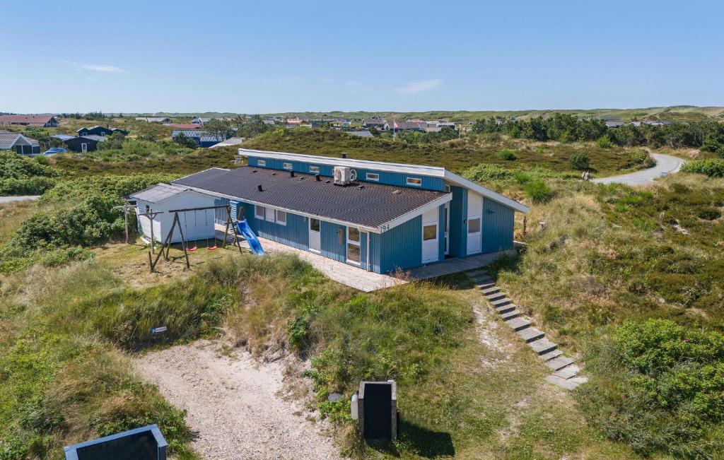 a blue house sitting on top of a hill at Holiday Home Bjerregårdsvej Hvide Sande Ds Denm in Bjerregård