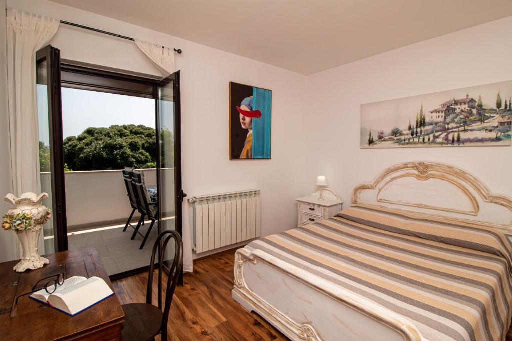 a bedroom with a bed and a window and a table at Apartman Lamanova in Rovinj