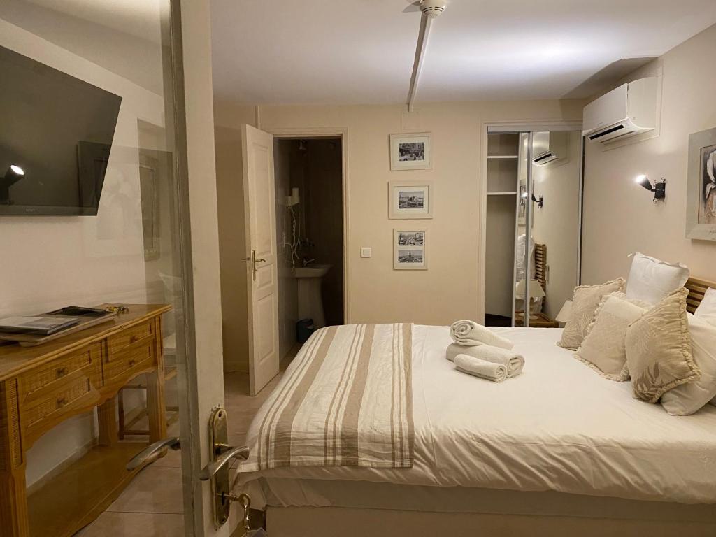 a bedroom with a bed with towels on it at Hotel Villa Maya in Saint-Tropez