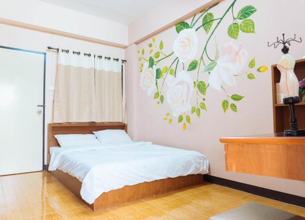 een slaapkamer met een bed met een muurschildering van bloemen aan de muur bij Chiangmai Tree Hostel in Chiang Mai