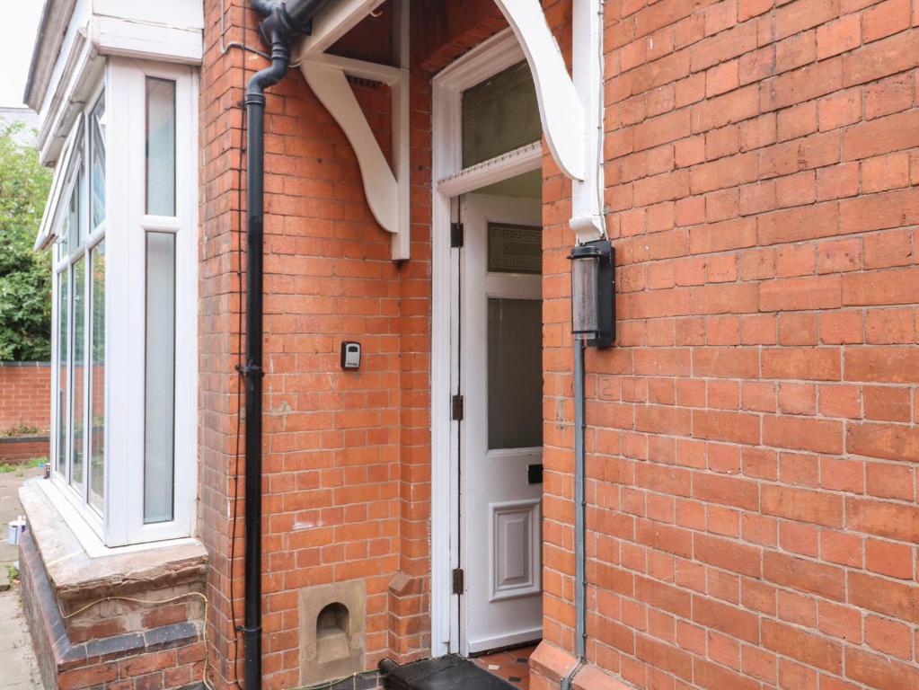 a red brick building with a white door at 2 Evington Road in Leicester