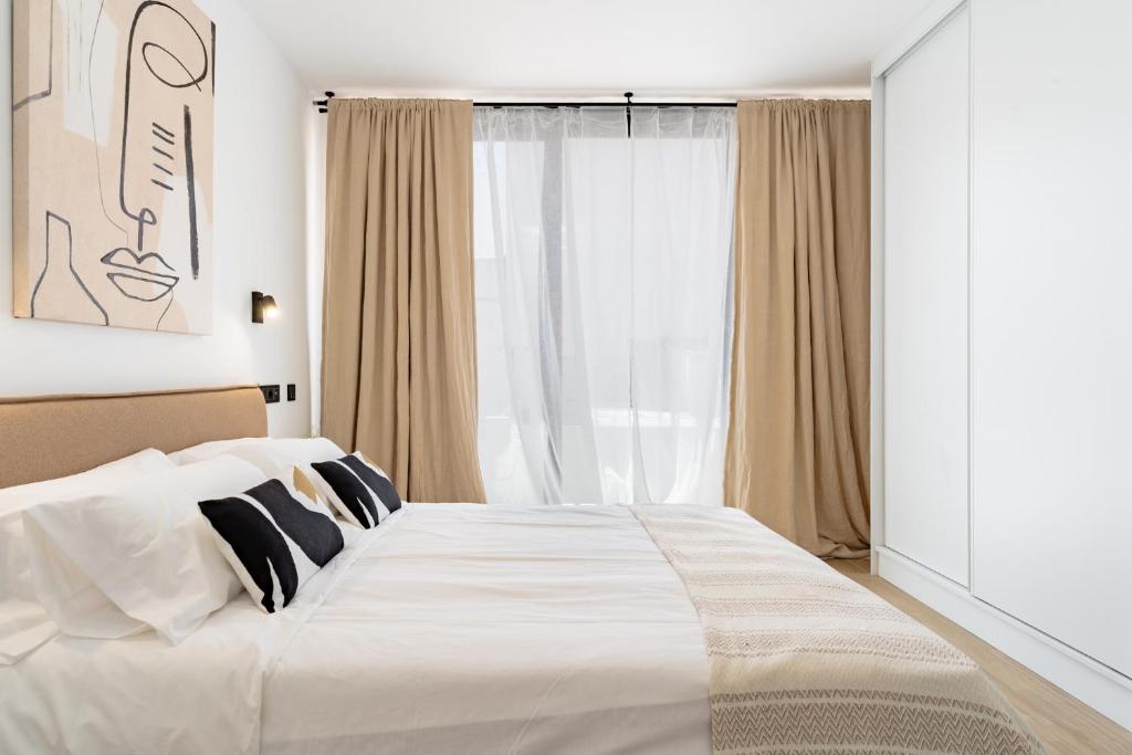 een slaapkamer met een groot wit bed en een raam bij Light Brisa Apartment in Fuengirola