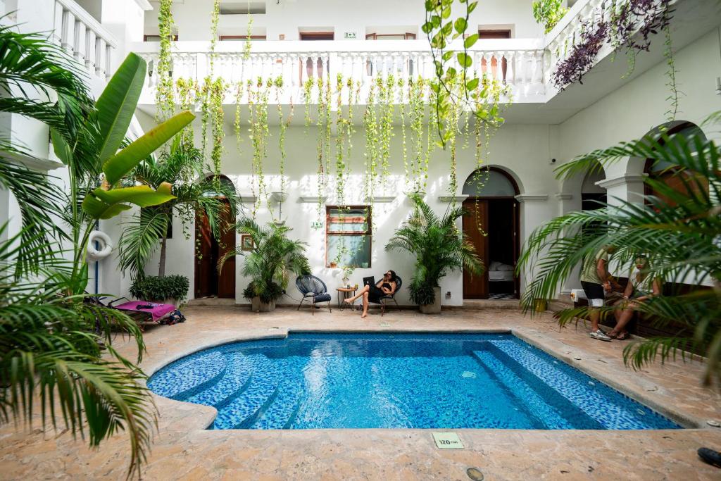 a swimming pool in a courtyard with plants at Masaya Santa Marta in Santa Marta