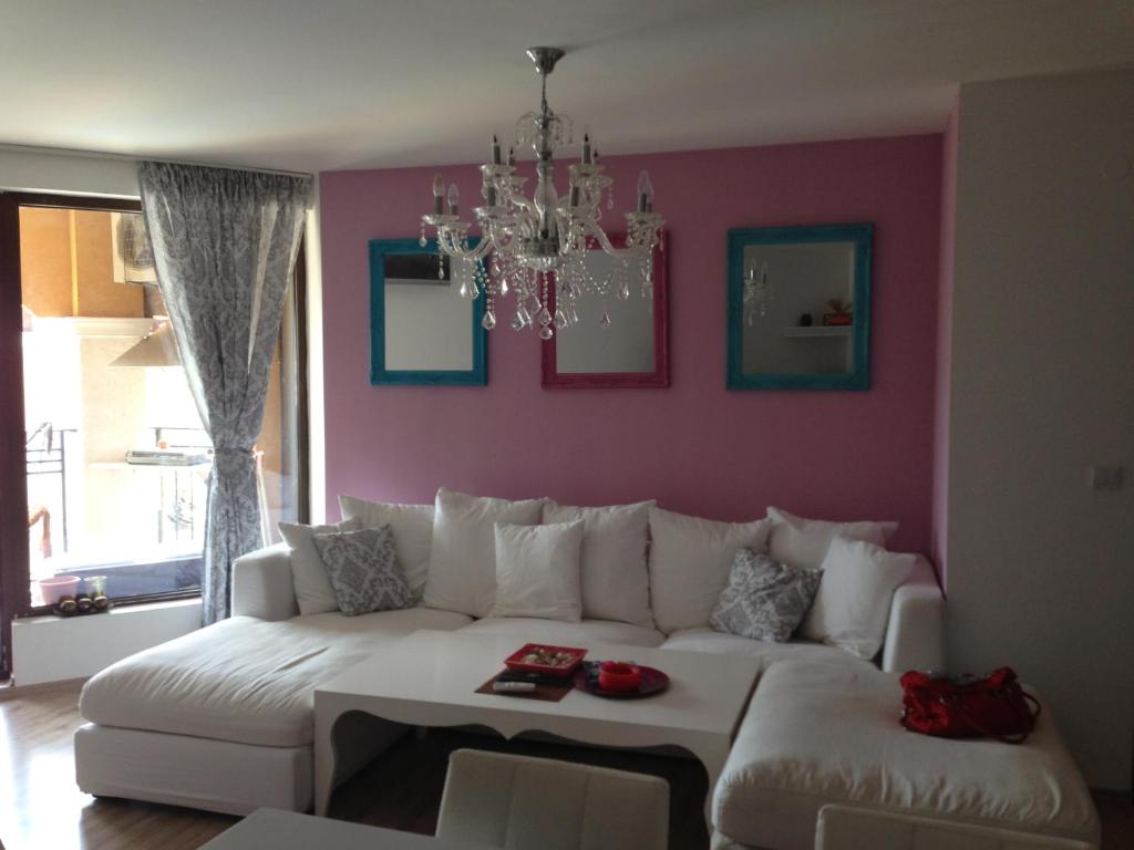 セインツ・コンスタンティン＆ヘレナにあるTsV Apartment Residenceの白いソファとピンクの壁が備わるリビングルーム