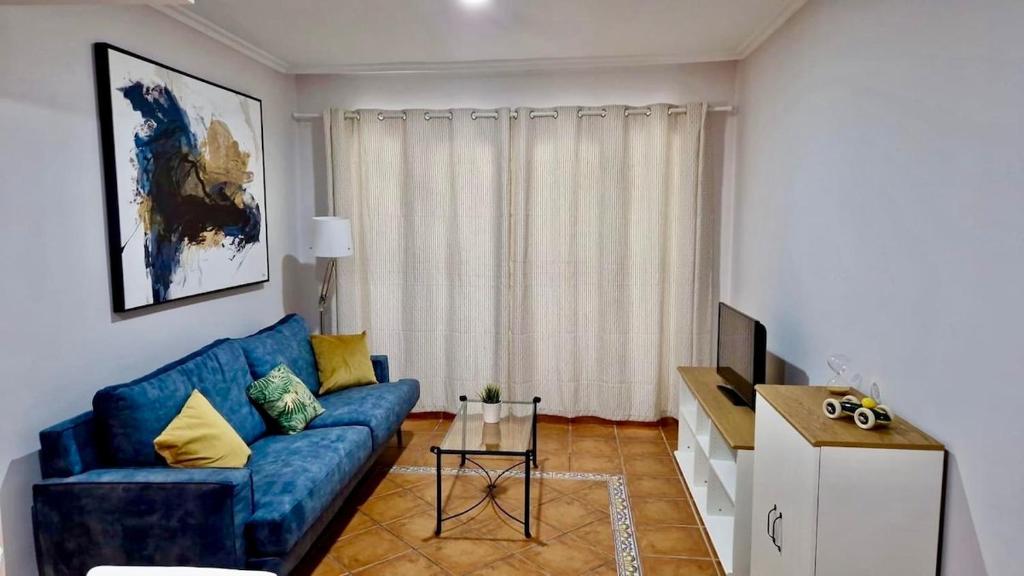 a living room with a blue couch and a tv at Heavenly Homes Mojcar 93 in Mojácar