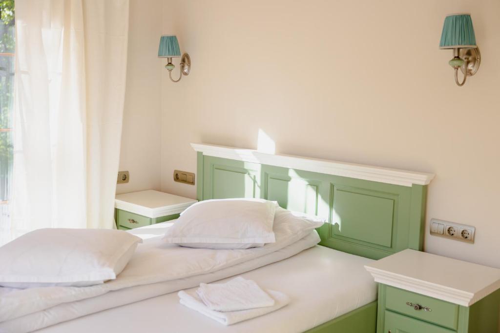 a bedroom with two beds with green and white at PENSIUNE RESTAURANT POIANA AVRIGULUI loc de joaca pentru copii in Avrig