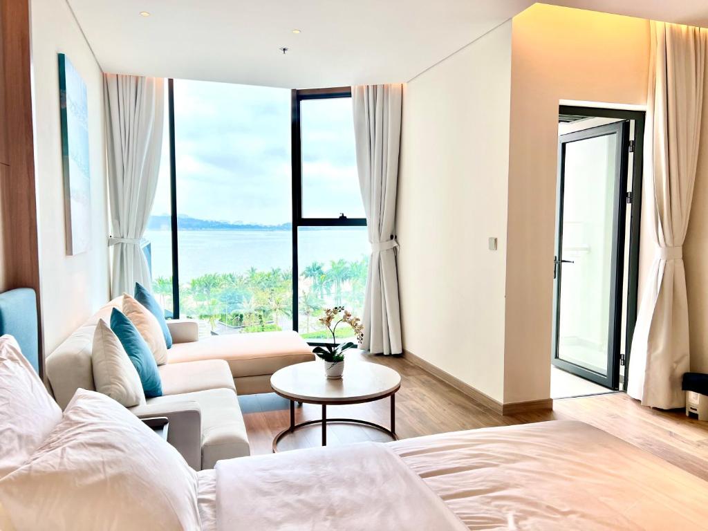 Un dormitorio con una cama, un sofá y una mesa. en Alacater hạ long bay, en Ha Long