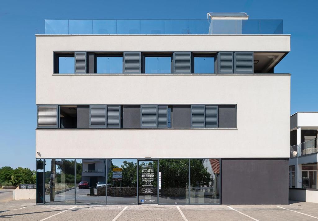 a white building with a parking lot at Apartment Adela in Vir