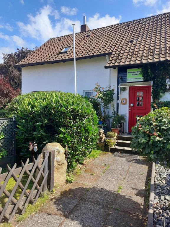 a small white house with a red door at Schatte's kleines Appartement in Seelze in Seelze
