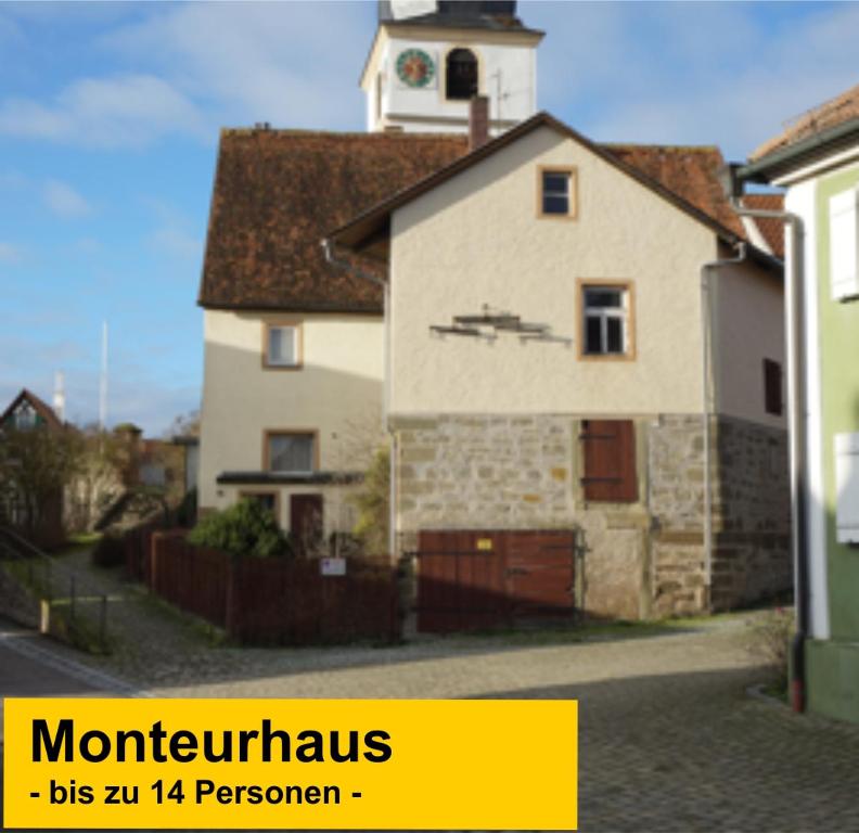 a large white house with a clock tower on top at Budget # MONTEURHAUS # Sugenheim in Sugenheim