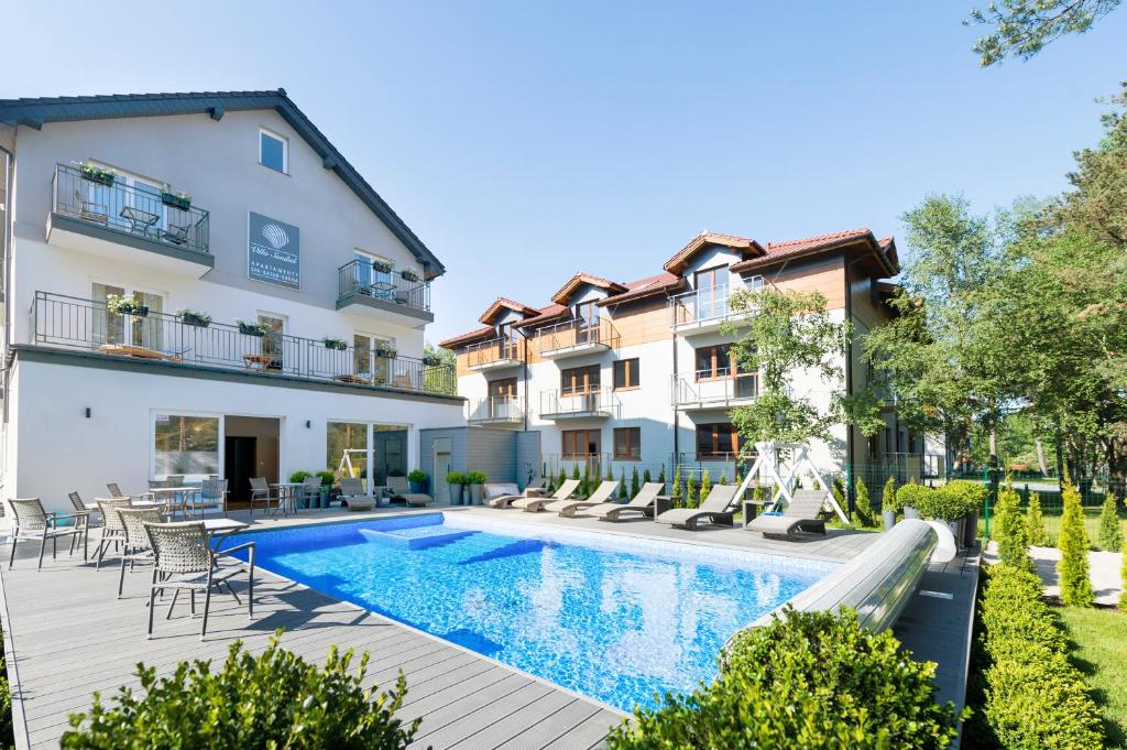 an apartment with a swimming pool and a building at Villa Sanibel in Bobolin