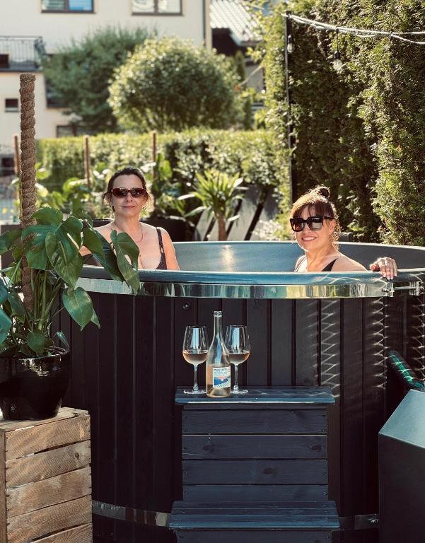 two women sitting in a hot tub with glasses of wine at Willa Atena in Łeba