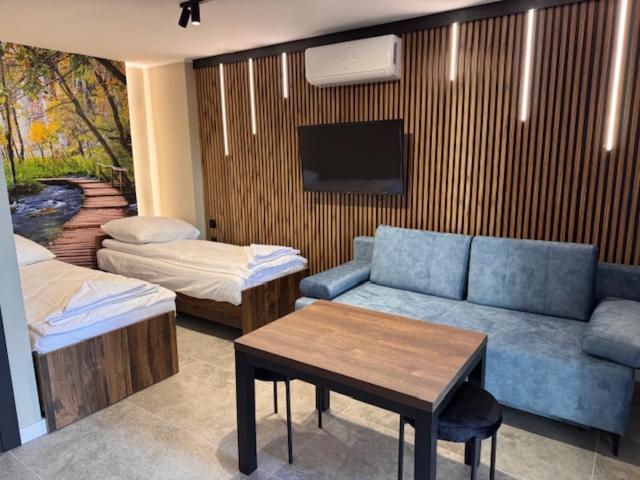 Una sala de estar con un sofá, una mesa y un televisor. en Turawa Lake Apartments, en Turawa