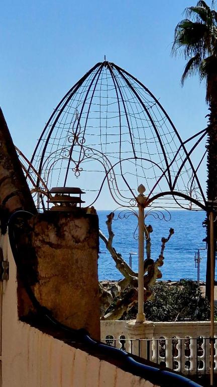 a sculpture of a cage on a wall near the ocean at Stone Rustic Beach apartment in Blanes