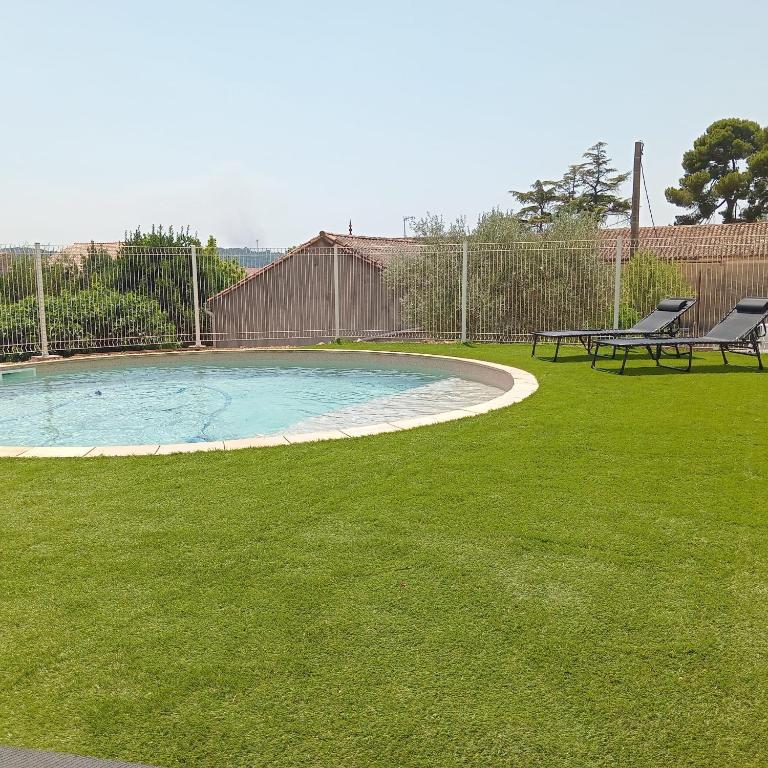 - une piscine dans une cour avec 2 chaises dans l'établissement Gîte Plaissan- Chez Laure&Marc, à Plaissan