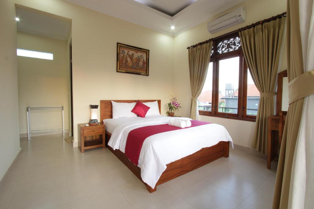 una camera con un grande letto e una finestra di Taman Ayu Ubud ad Ubud