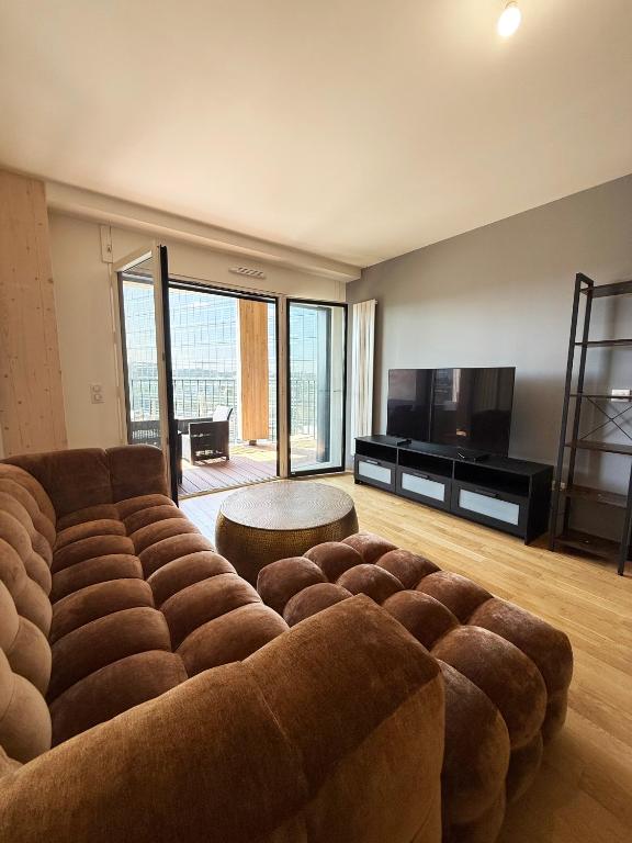 - un salon avec un grand canapé et une télévision dans l'établissement Charme Parisien neuf et cosy, à Paris