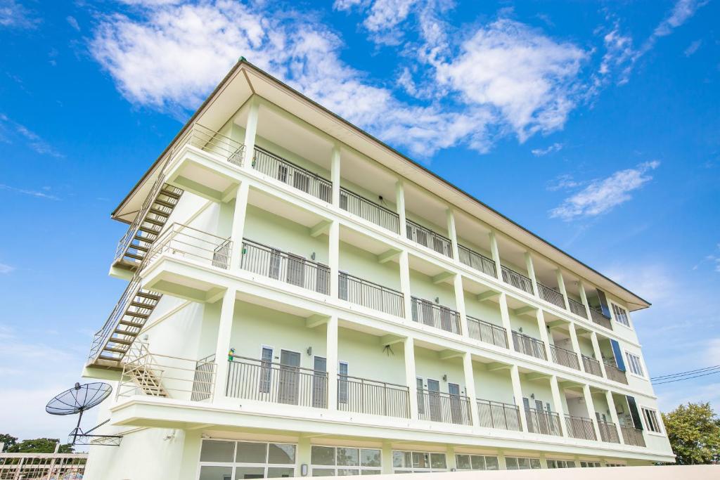 un edificio blanco con balcones y un cielo azul en J-House Phetchaburi en Phetchaburi