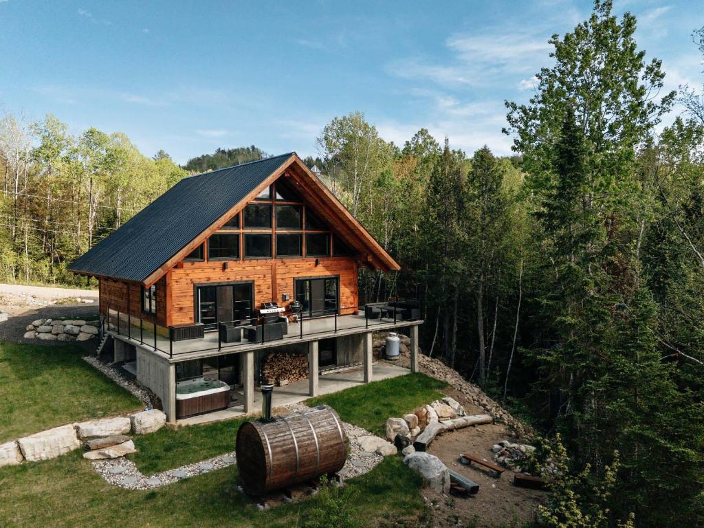 a log cabin in the woods with a barrel at Le Vertige - Ski Spa & Sauna in Saint Come