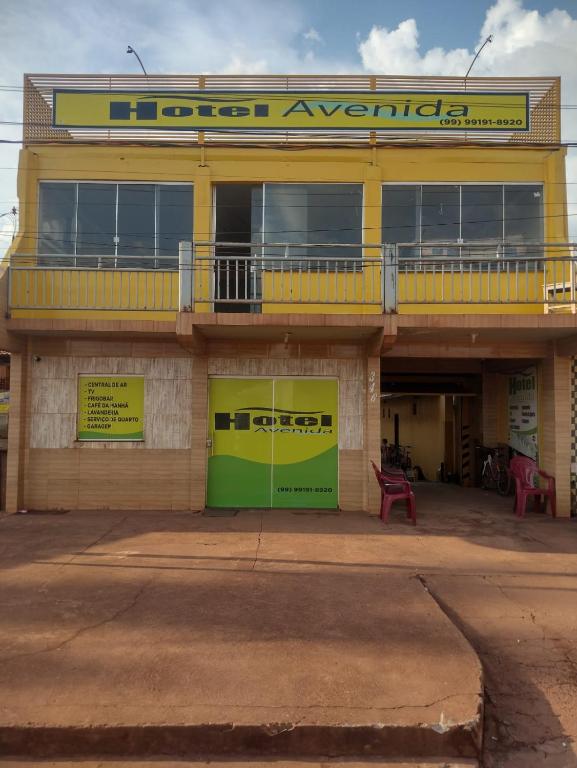 a yellow and green building with a sign on it at Hotel Avenida in Acailandia