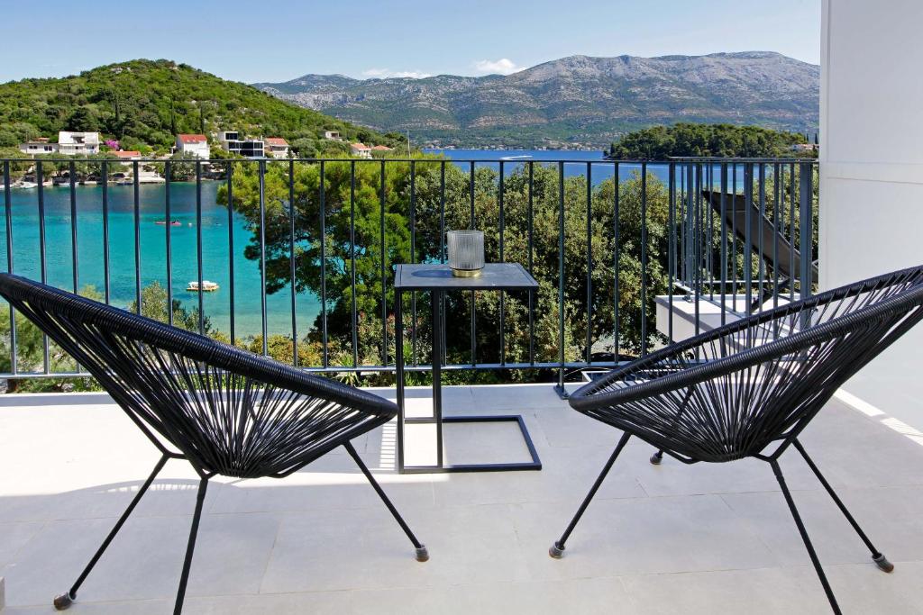 two chairs on a balcony with a view of a pool at MaMi in Korčula