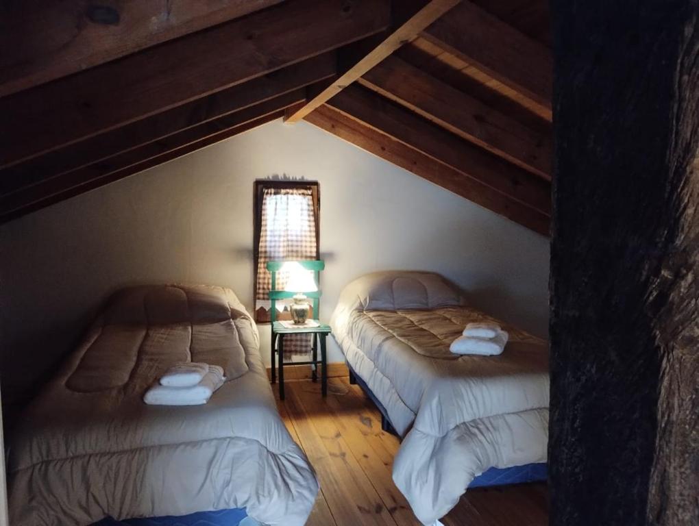 zwei Einzelbetten in einem Zimmer mit Fenster in der Unterkunft Casas Buen Camino y La Magia in Sierra de la Ventana