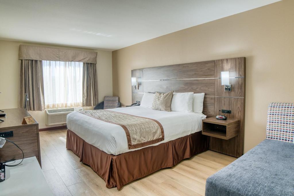 Postel nebo postele na pokoji v ubytování Evergreen Inn & Suites