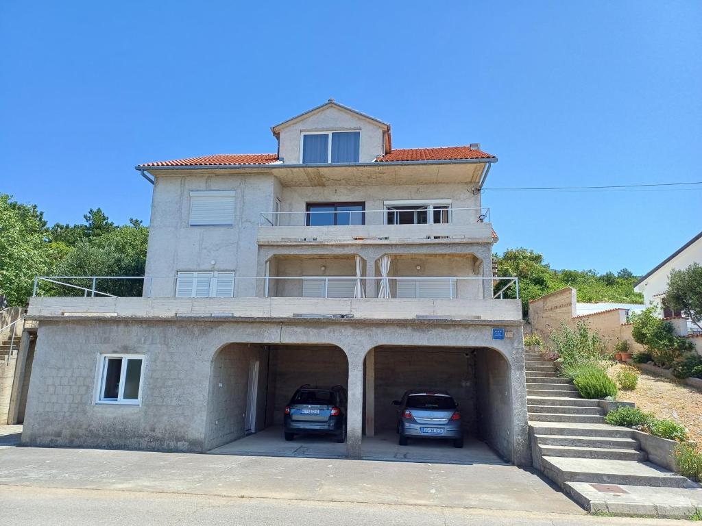 a house with two cars parked in a garage at Apartments by the sea Klenovica, Novi Vinodolski - 5581 in Klenovica