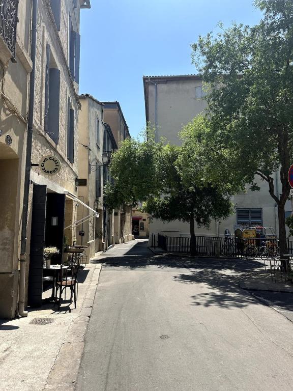 an empty street with tables and a tree in a city at T2 Au Coeur de Montpellier in Montpellier
