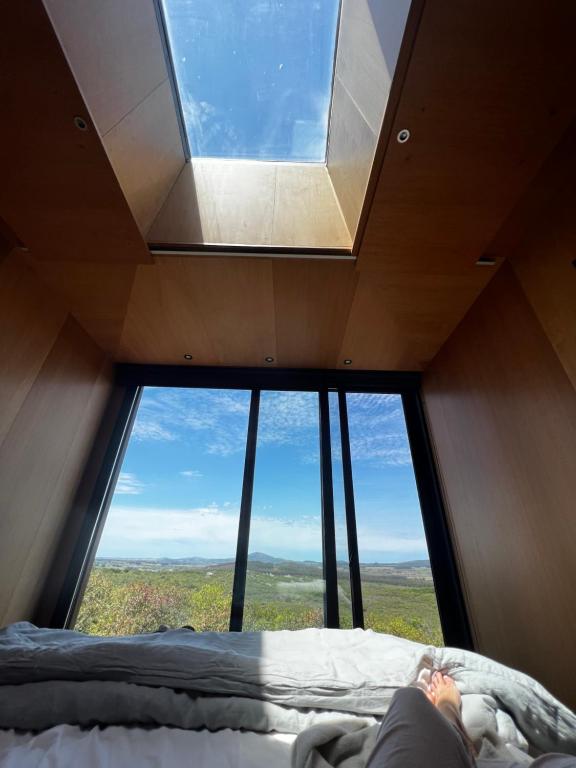 a person laying on a bed in front of a large window at Casa Mara Sierra 2 in Nueva Carrara