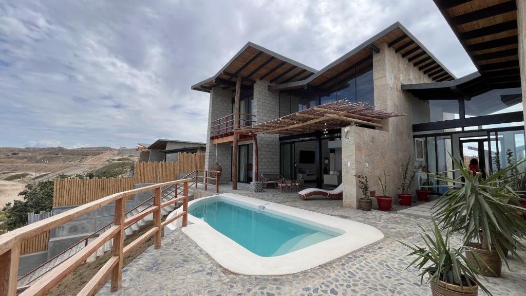 a house with a swimming pool on a patio at Villas Gratiam - Piscina Privada, Mar y Naturaleza en Vichayito in Los Órganos