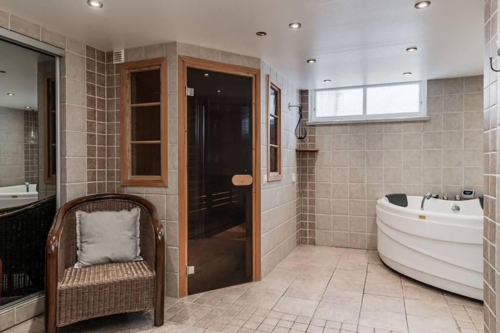 a bathroom with a large tub and a sink at Gylle Luxe & Retreat in Borlänge