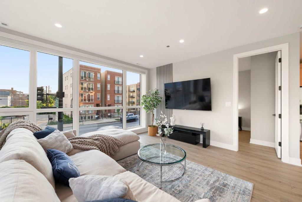a living room with a couch and a large window at New Build in Pilsen Spacious 2 Bed 2 Bath Unit in Chicago