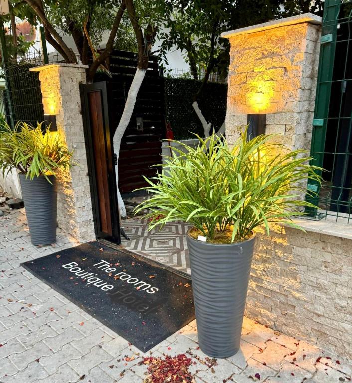 three potted plants sitting in front of a door at The rooms hotel in Kumbağ