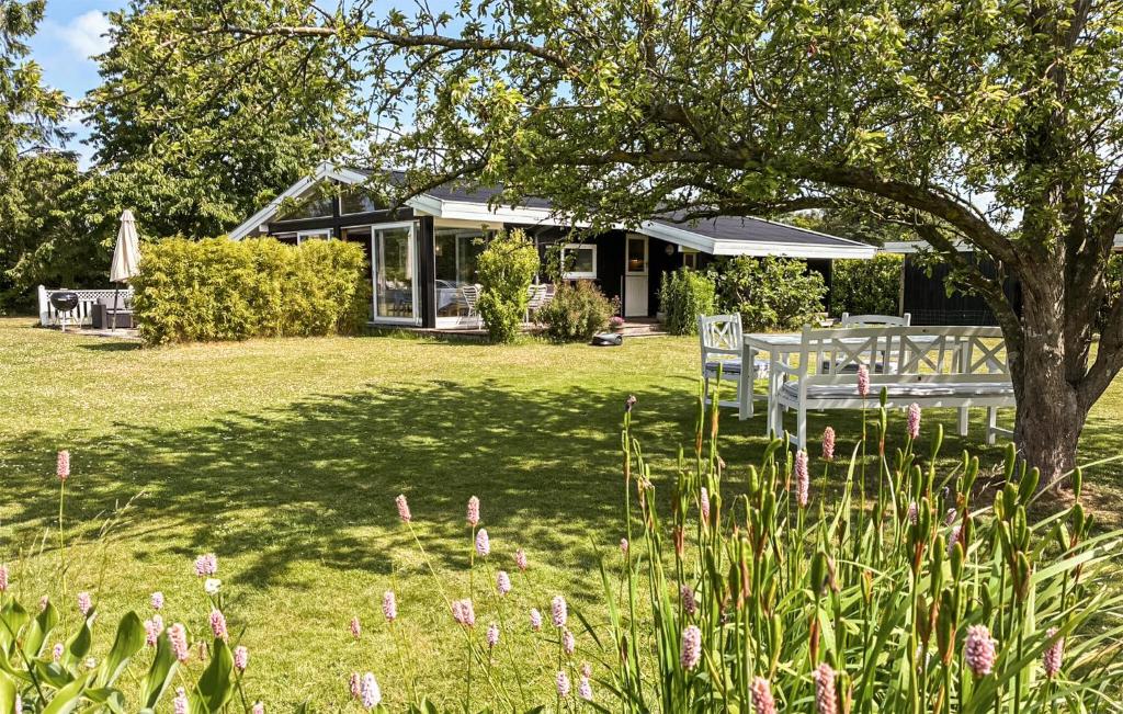 a house with a table and chairs under a tree at Gorgeous Home In Gilleleje With Wifi in Gilleleje