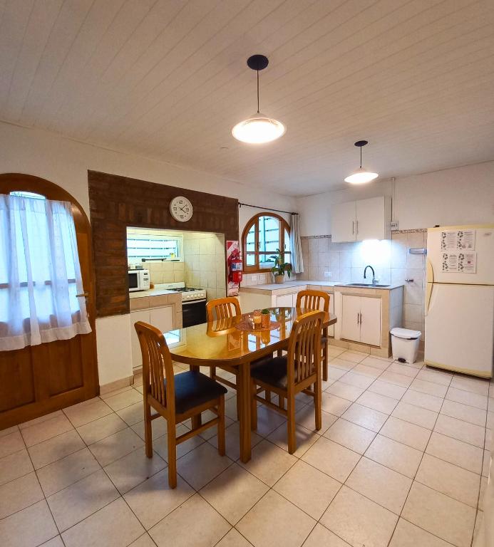 a kitchen with a table and chairs and a refrigerator at Departamento Mamá Inés in Esquel