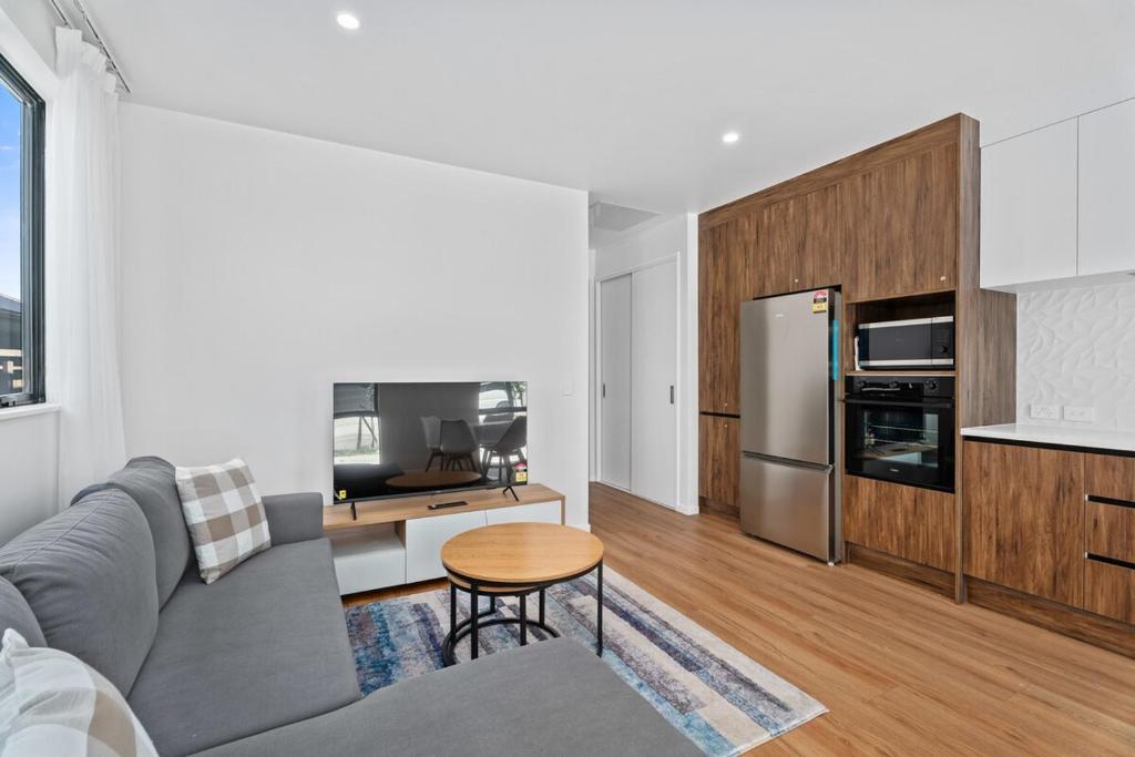 sala de estar con sofá gris y cocina en Stylish 1BR Escape Near Remarks, en Queenstown Airport