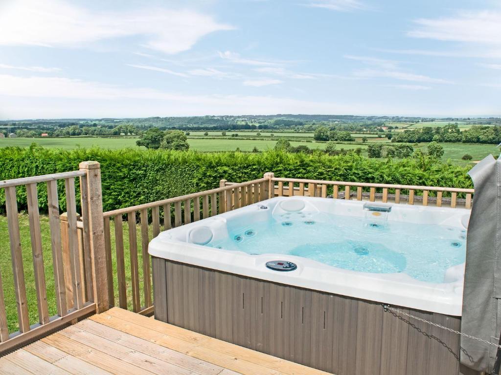 eine Whirlpool-Badewanne auf einer Holzterrasse in der Unterkunft Primrose Cottage - Uk49219 in Burythorpe