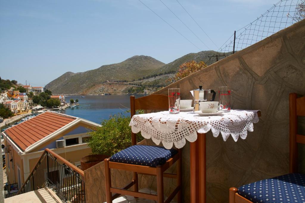 a table on a balcony with a view of the water at Athina Studios in Symi