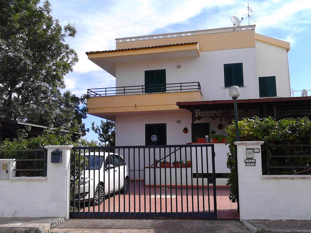 una casa blanca con una puerta y un coche en Villa Anna en Ginosa Marina