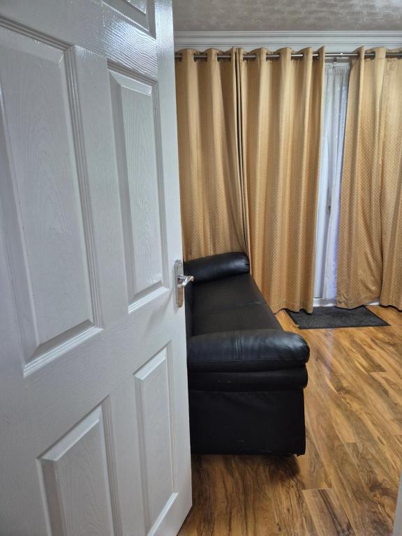 a black leather chair sitting in front of a door at Comfy and modern private room in Birmingham 