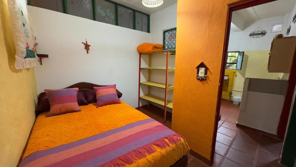 1 dormitorio con 1 cama con sábanas y almohadas coloridas en Refugio tornasol, en Duitama